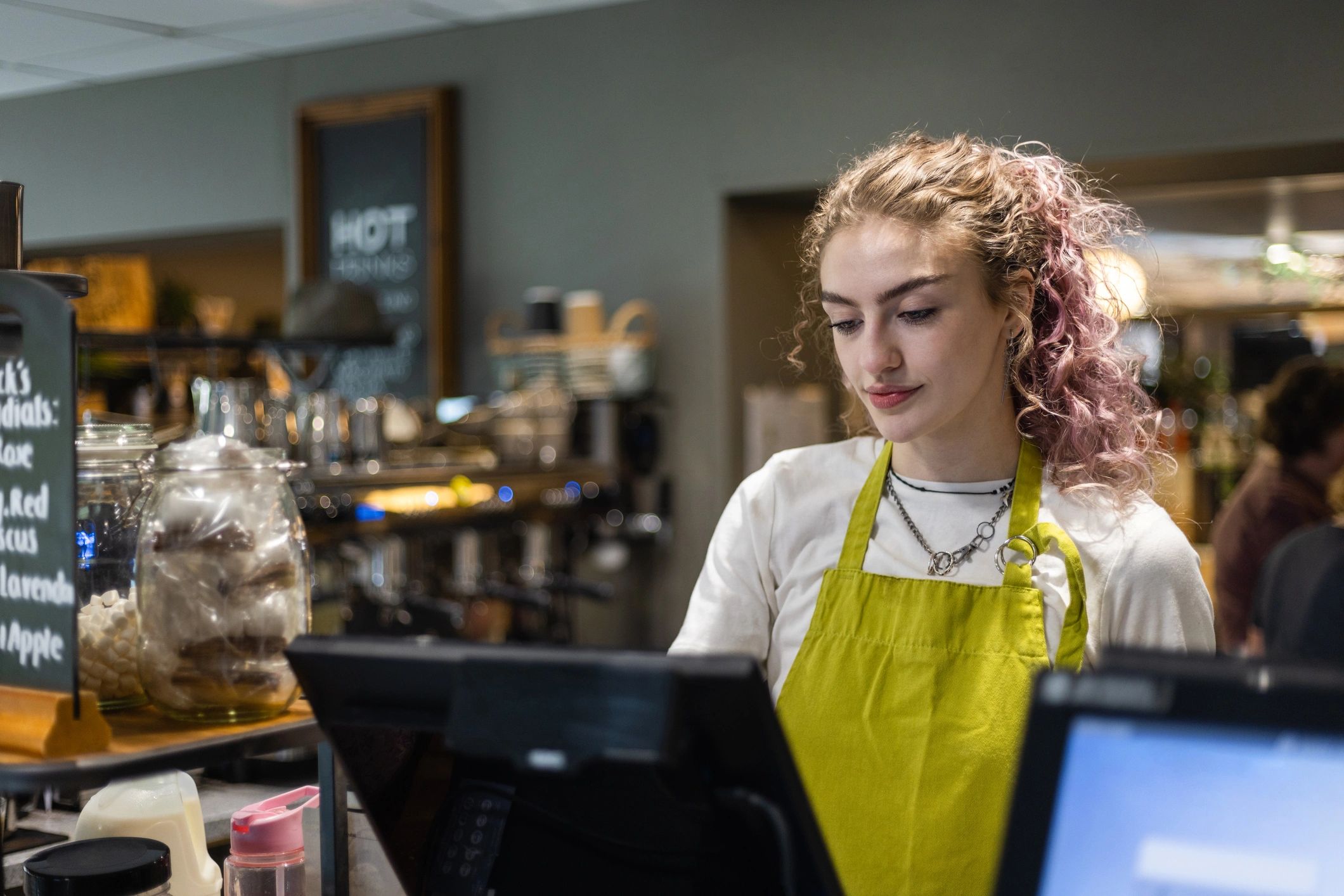 Cafe staff member operating a POS till