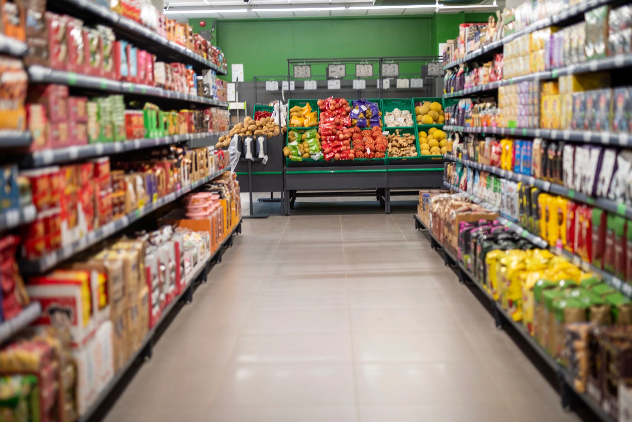 Supermarket aisle with shelves and fresh produce